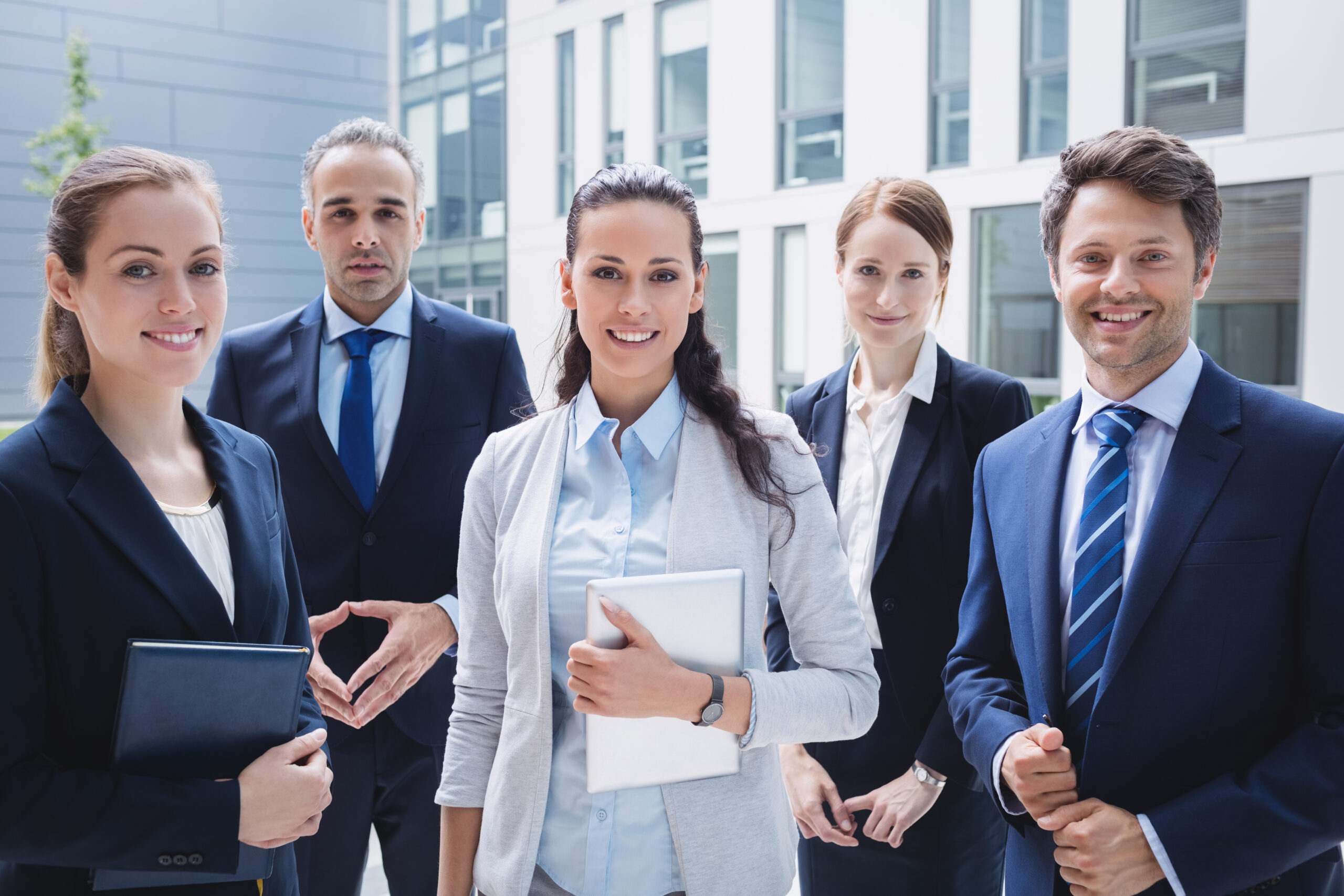 Portrait of confident businesspeople standing outside office building